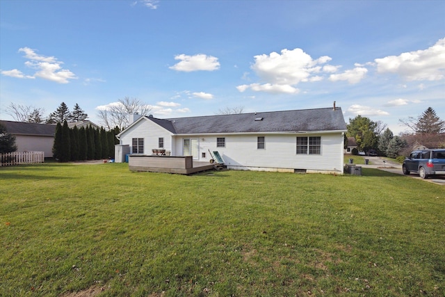 rear view of house featuring a lawn, central AC unit, and a deck