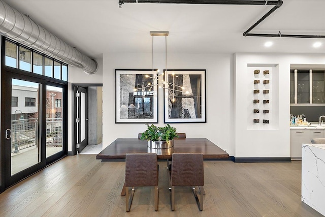 dining room with light hardwood / wood-style floors, a wealth of natural light, and a notable chandelier