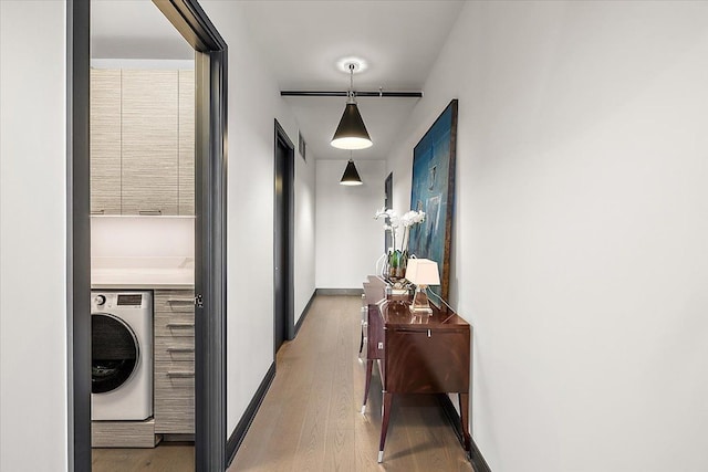 hallway featuring washer / dryer and wood-type flooring