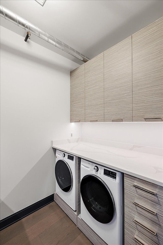 laundry area with dark hardwood / wood-style flooring, cabinets, and washing machine and dryer