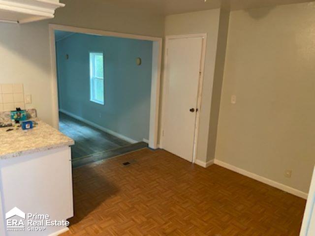 interior space featuring white cabinets and dark parquet floors