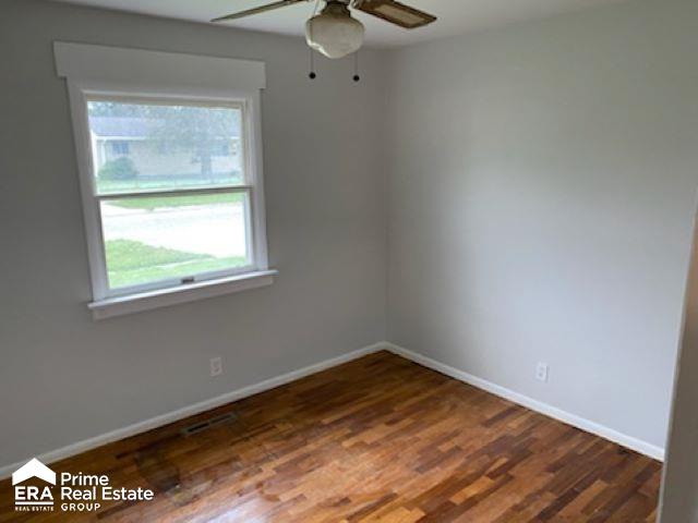 spare room featuring ceiling fan and dark hardwood / wood-style flooring