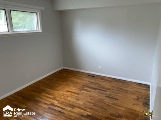 empty room with dark hardwood / wood-style flooring