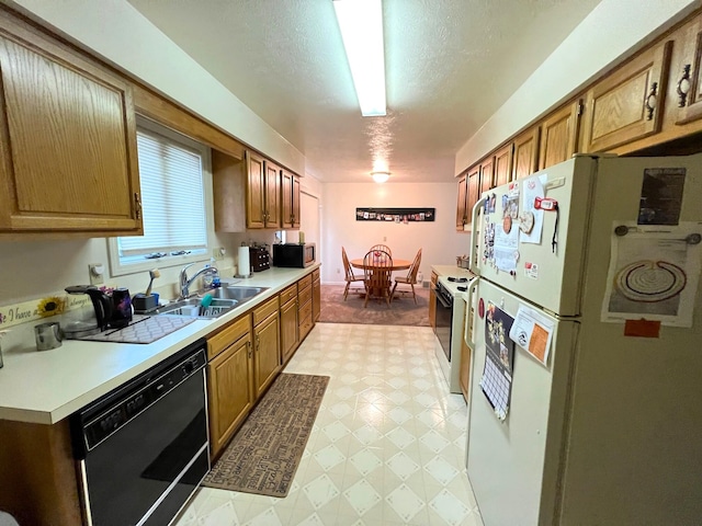 kitchen featuring a textured ceiling, sink, and white appliances