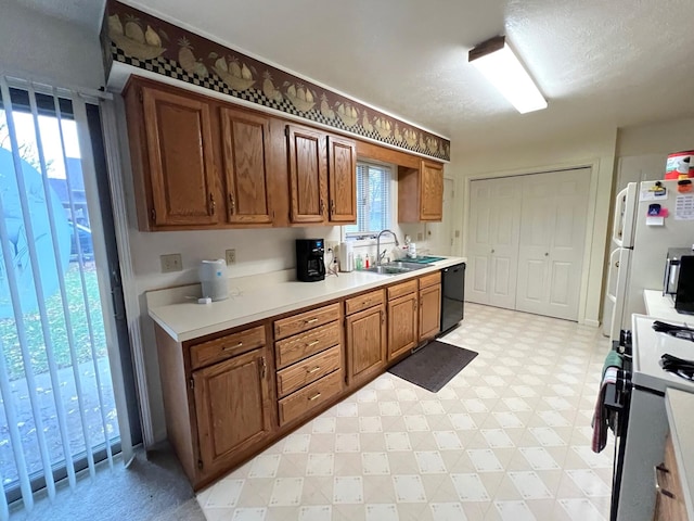 kitchen featuring a textured ceiling, sink, and white appliances