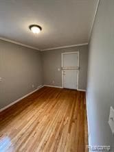 unfurnished room with hardwood / wood-style flooring and ornamental molding