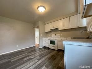 kitchen featuring white cabinets, white range oven, dark hardwood / wood-style floors, and sink