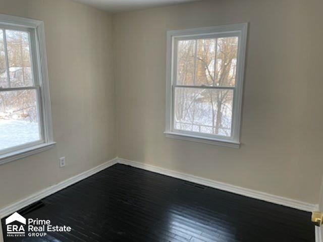 spare room featuring hardwood / wood-style floors and a healthy amount of sunlight