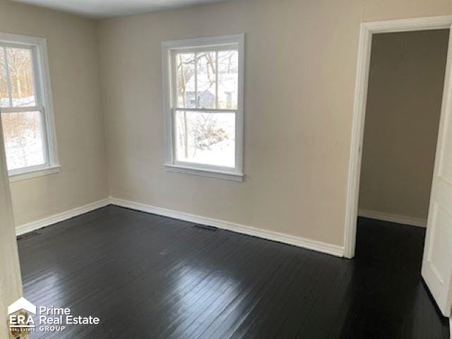 spare room with dark hardwood / wood-style floors and a wealth of natural light