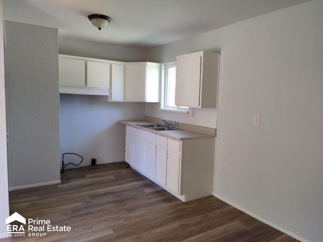 2014 Daron Pl, Flint, MI 48505 - kitchen featuring a sink, white cabinets, dark wood-style floors, light countertops, and baseboards