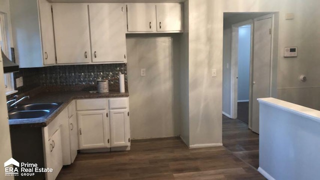 kitchen with dark hardwood / wood-style flooring, white cabinetry, sink, and tasteful backsplash