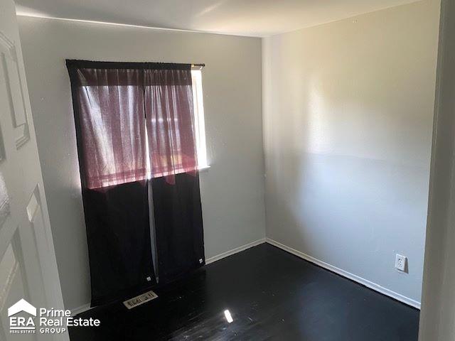 unfurnished room with dark wood-type flooring