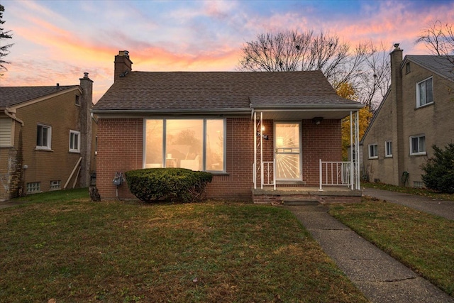 view of front of house featuring covered porch and a lawn