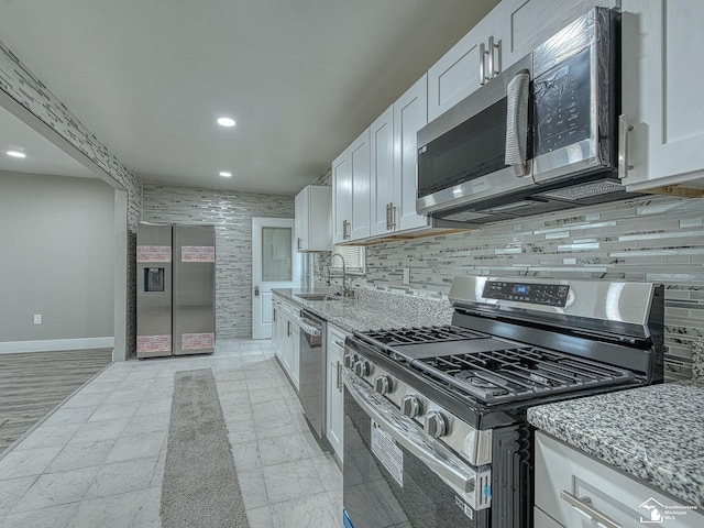 3495 Vermont Ct, Monroe, MI 48161 - kitchen with stainless steel appliances, baseboards, a sink, recessed lighting, and white cabinetry