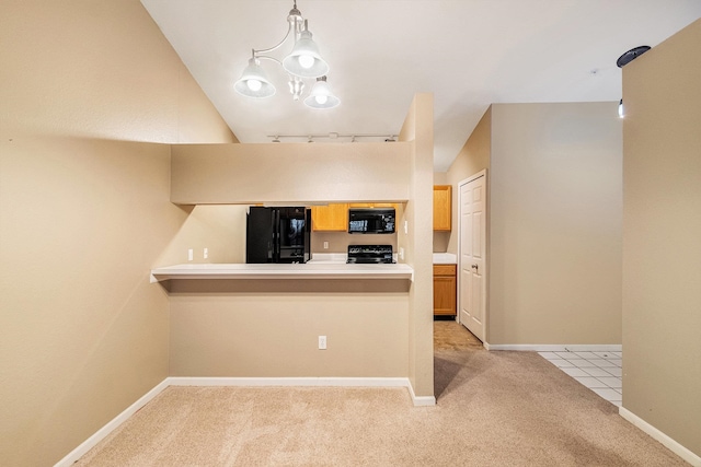 kitchen featuring kitchen peninsula, vaulted ceiling, decorative light fixtures, light carpet, and black appliances