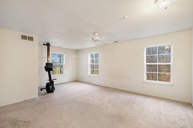 carpeted spare room featuring ceiling fan and a textured ceiling