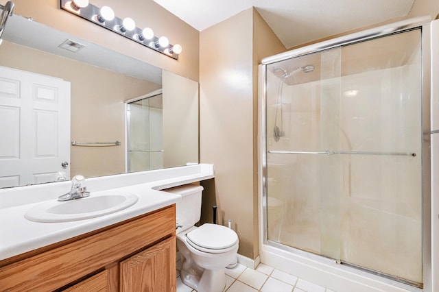 bathroom with tile patterned flooring, vanity, toilet, and a shower with shower door