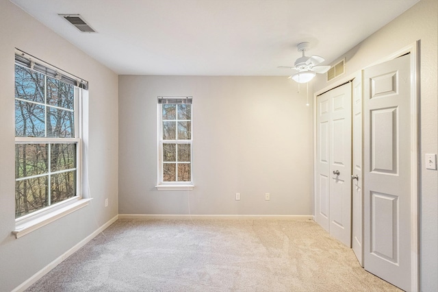 unfurnished room with light colored carpet and ceiling fan