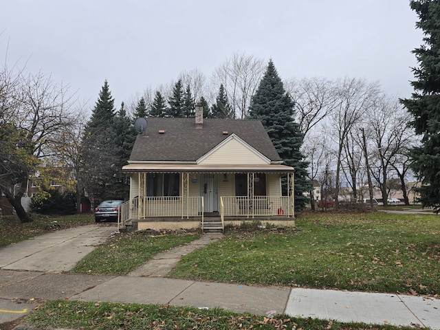 bungalow-style home featuring covered porch and a front yard