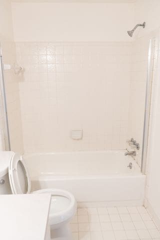 full bathroom with vanity, tile patterned floors, tiled shower / bath combo, and toilet