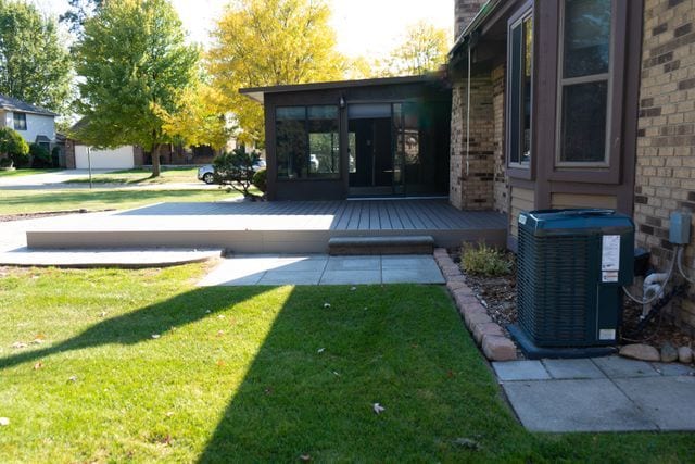 view of yard with a wooden deck and central air condition unit