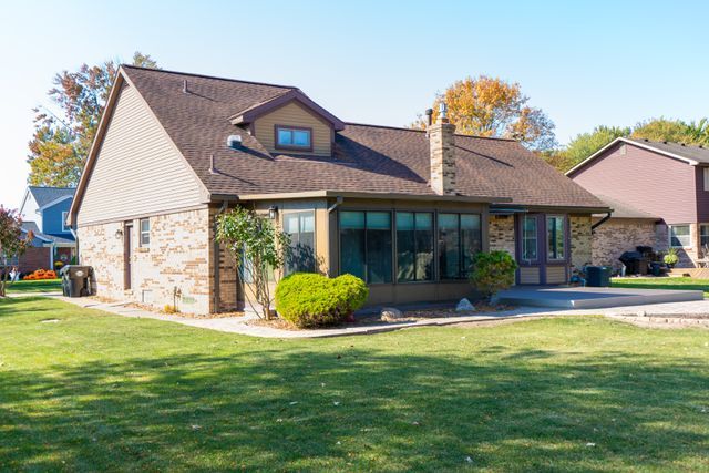 back of house featuring a yard and a sunroom