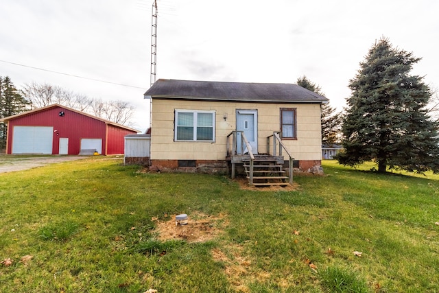 bungalow-style home with a garage, an outbuilding, and a front lawn