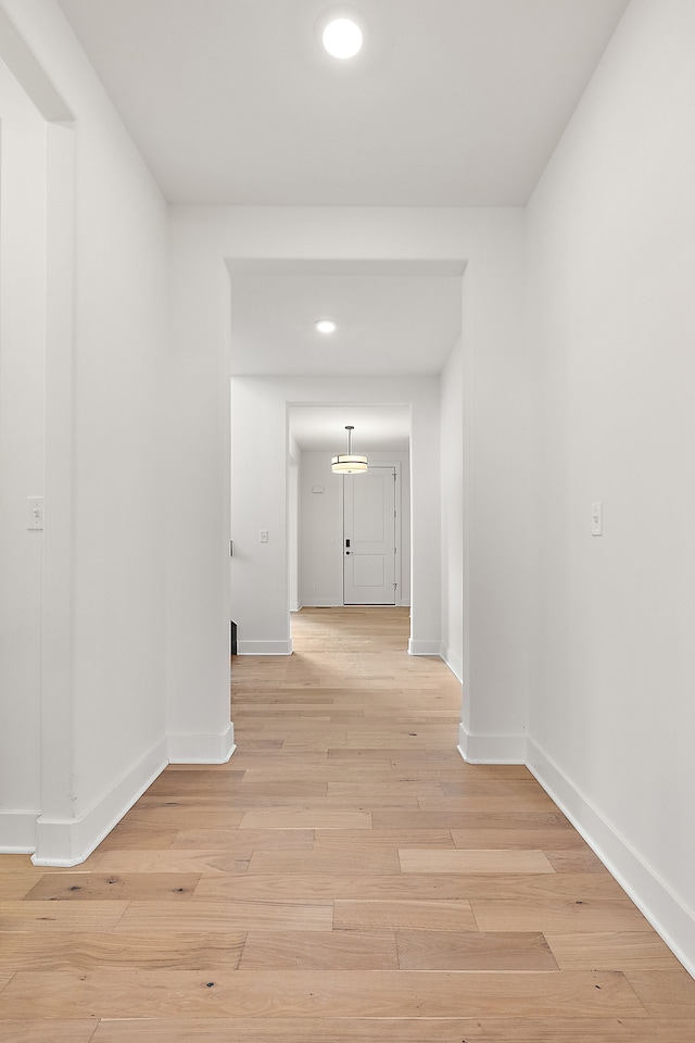 hallway with light hardwood / wood-style floors