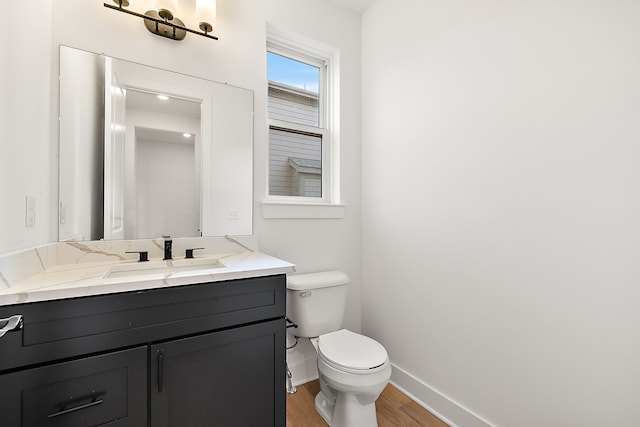 bathroom with vanity, toilet, and wood-type flooring