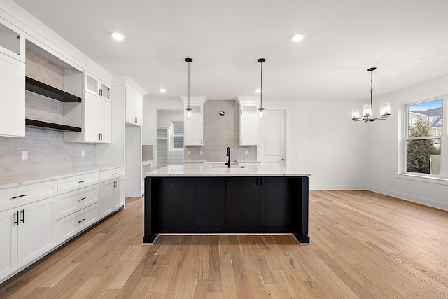 kitchen with white cabinetry, light wood-type flooring, and hanging light fixtures