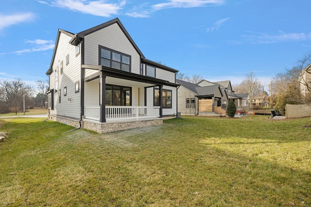 back of house featuring a lawn and covered porch