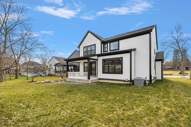 rear view of house with a porch, central air condition unit, and a lawn