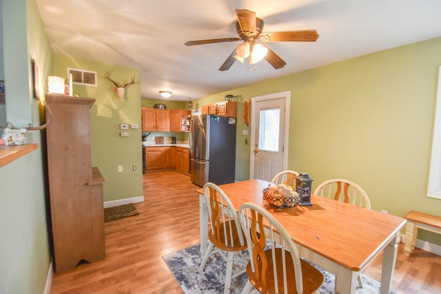 dining room with light hardwood / wood-style floors and ceiling fan