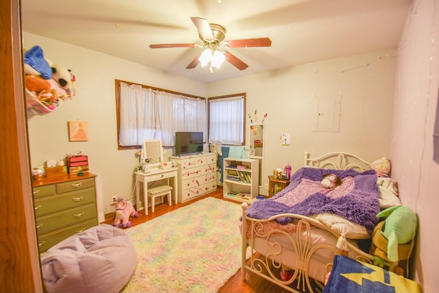 bedroom with electric panel, ceiling fan, and hardwood / wood-style floors