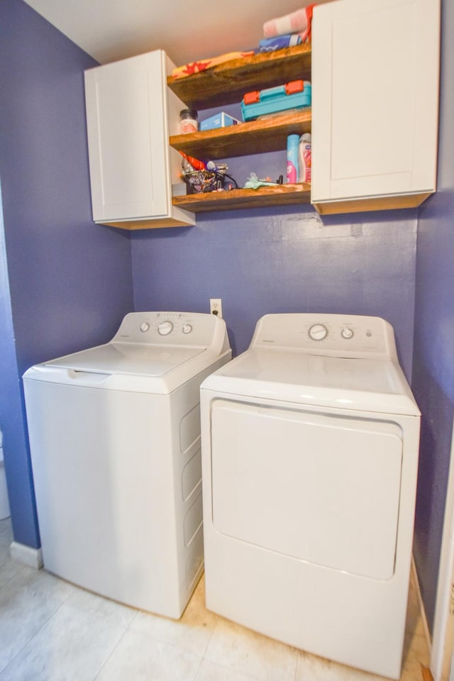 washroom featuring cabinets, light tile patterned floors, and separate washer and dryer