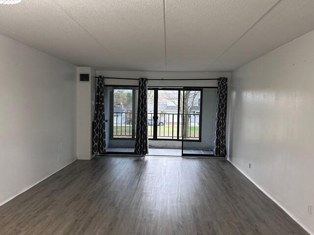 21800 Morley Ave Unit 101, Dearborn, MI 48124 - empty room featuring dark wood-type flooring, a textured ceiling, and baseboards