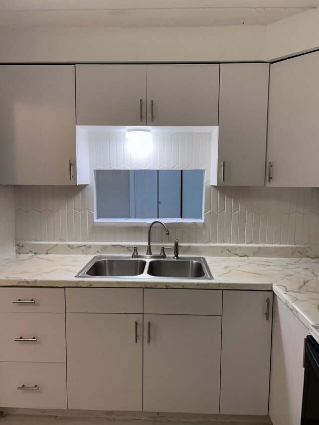 21800 Morley Ave Unit 101, Dearborn, MI 48124 - kitchen featuring a sink, decorative backsplash, and white cabinetry