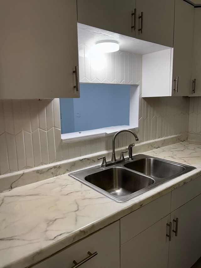 21800 Morley Ave Unit 101, Dearborn, MI 48124 - kitchen with a sink, decorative backsplash, and white cabinetry