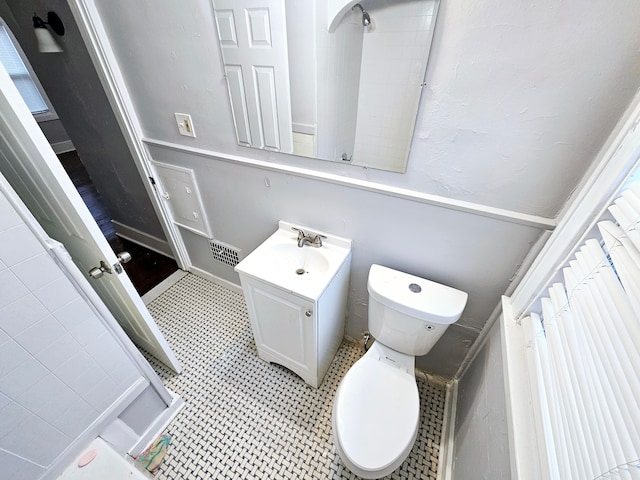 bathroom with walk in shower, vanity, and toilet