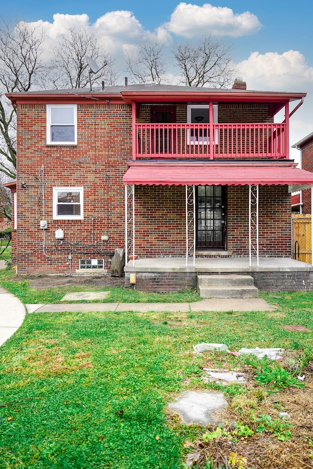 back of house with a lawn and a balcony