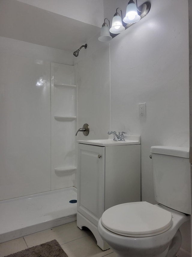 bathroom featuring tile patterned flooring, vanity, toilet, and walk in shower