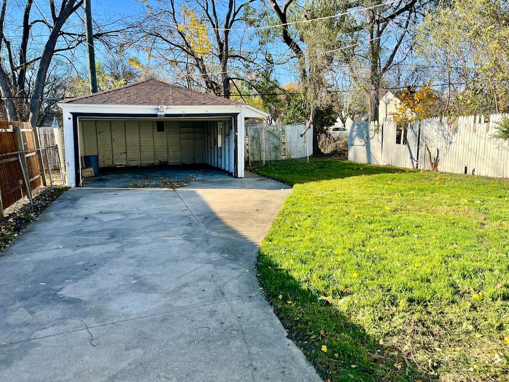 view of yard with a garage and an outbuilding