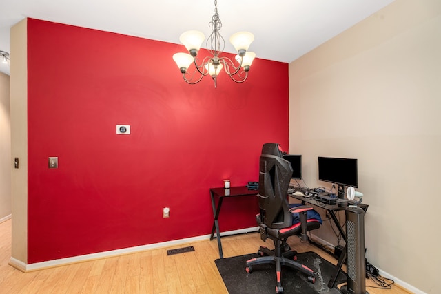 home office featuring a notable chandelier and hardwood / wood-style flooring