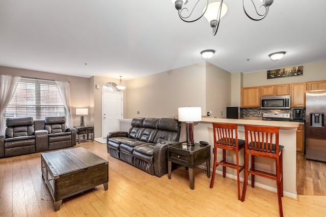 living room with a notable chandelier and light wood-type flooring