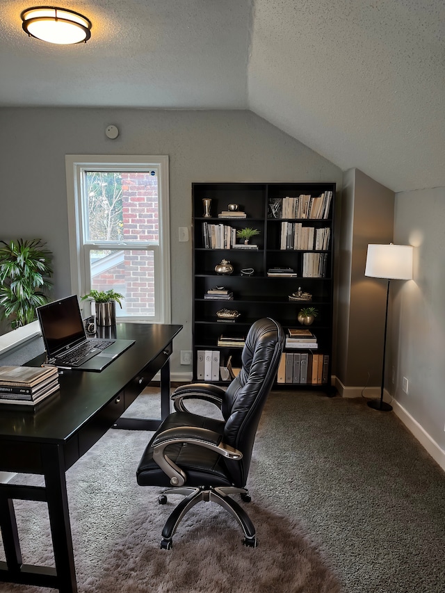 carpeted home office with vaulted ceiling and a textured ceiling