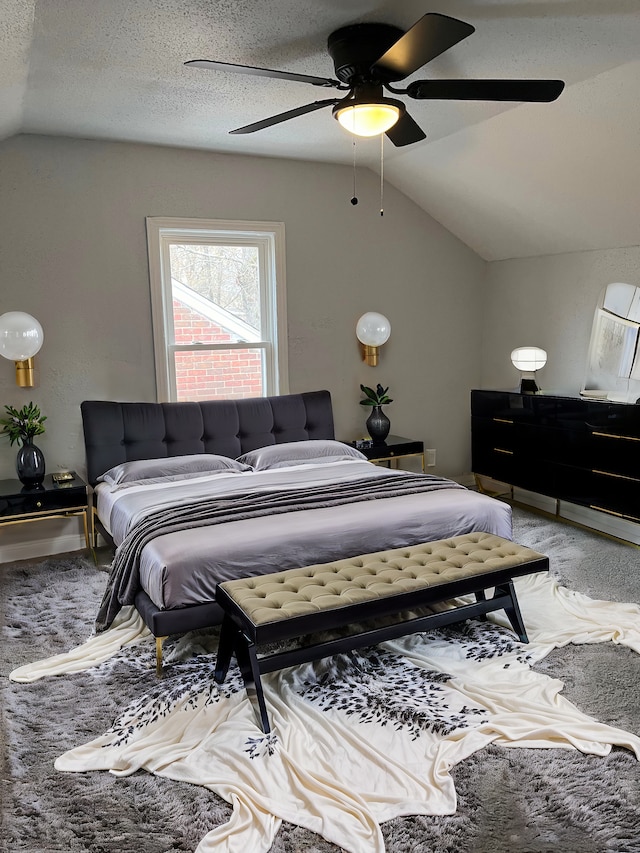 carpeted bedroom featuring a textured ceiling, vaulted ceiling, and ceiling fan