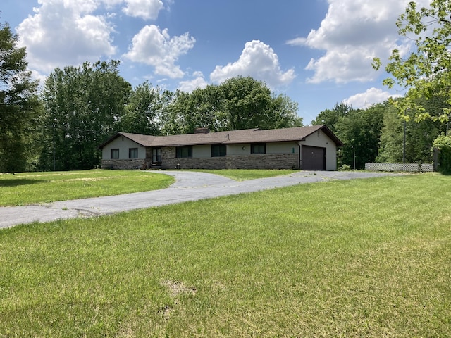 single story home featuring a garage and a front lawn