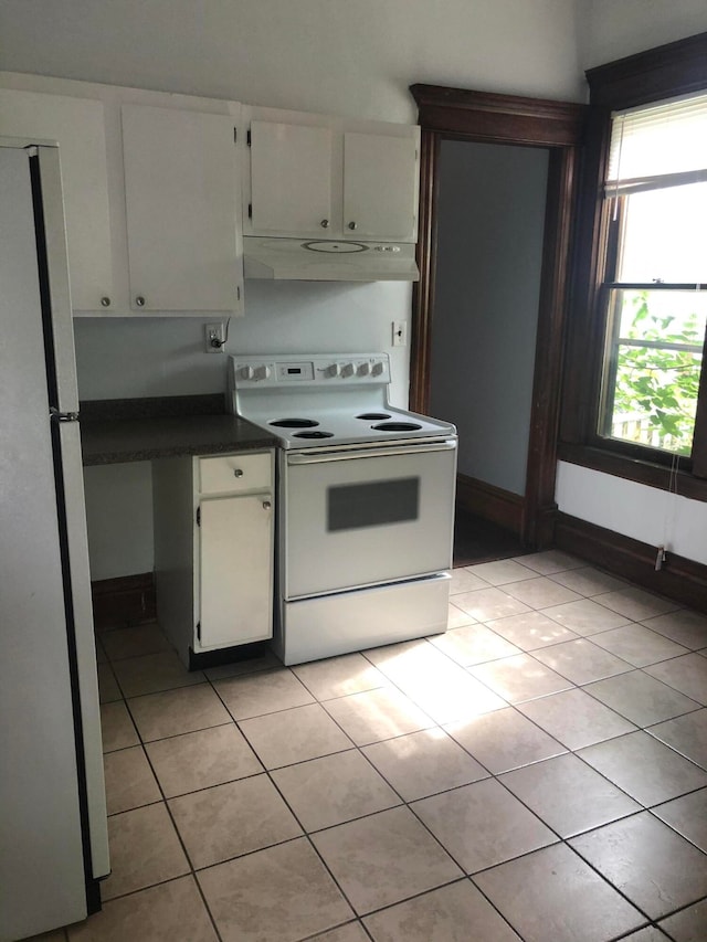 kitchen featuring light tile patterned floors, electric range, white refrigerator, and white cabinetry