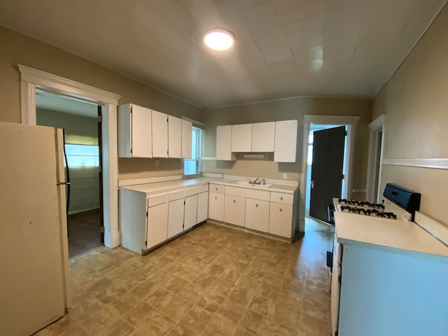 kitchen featuring sink, white cabinets, and white appliances