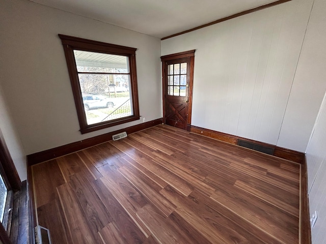 empty room with dark hardwood / wood-style flooring and ornamental molding